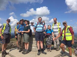A group of walkers and guides at the peak of a hill