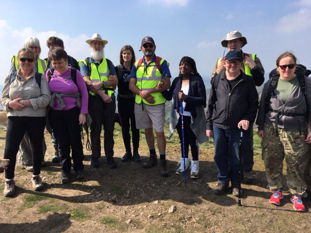 A group of walkers smile in the sunshine.