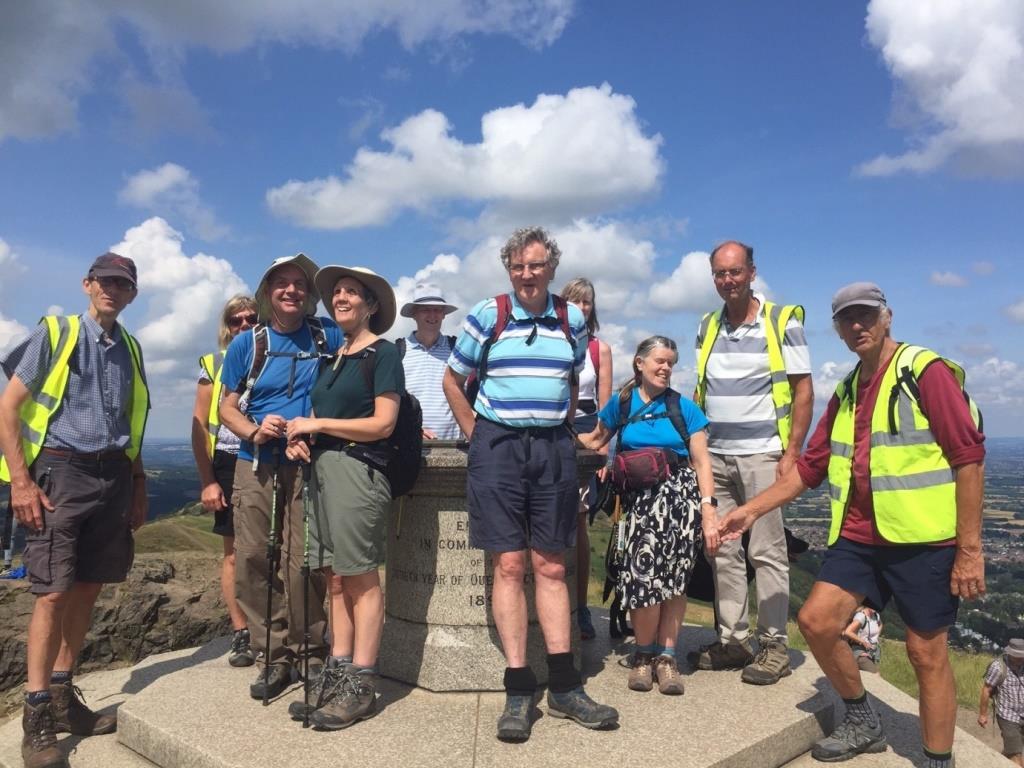 A group of walkers smile at the top of the Worcestershire Beacon